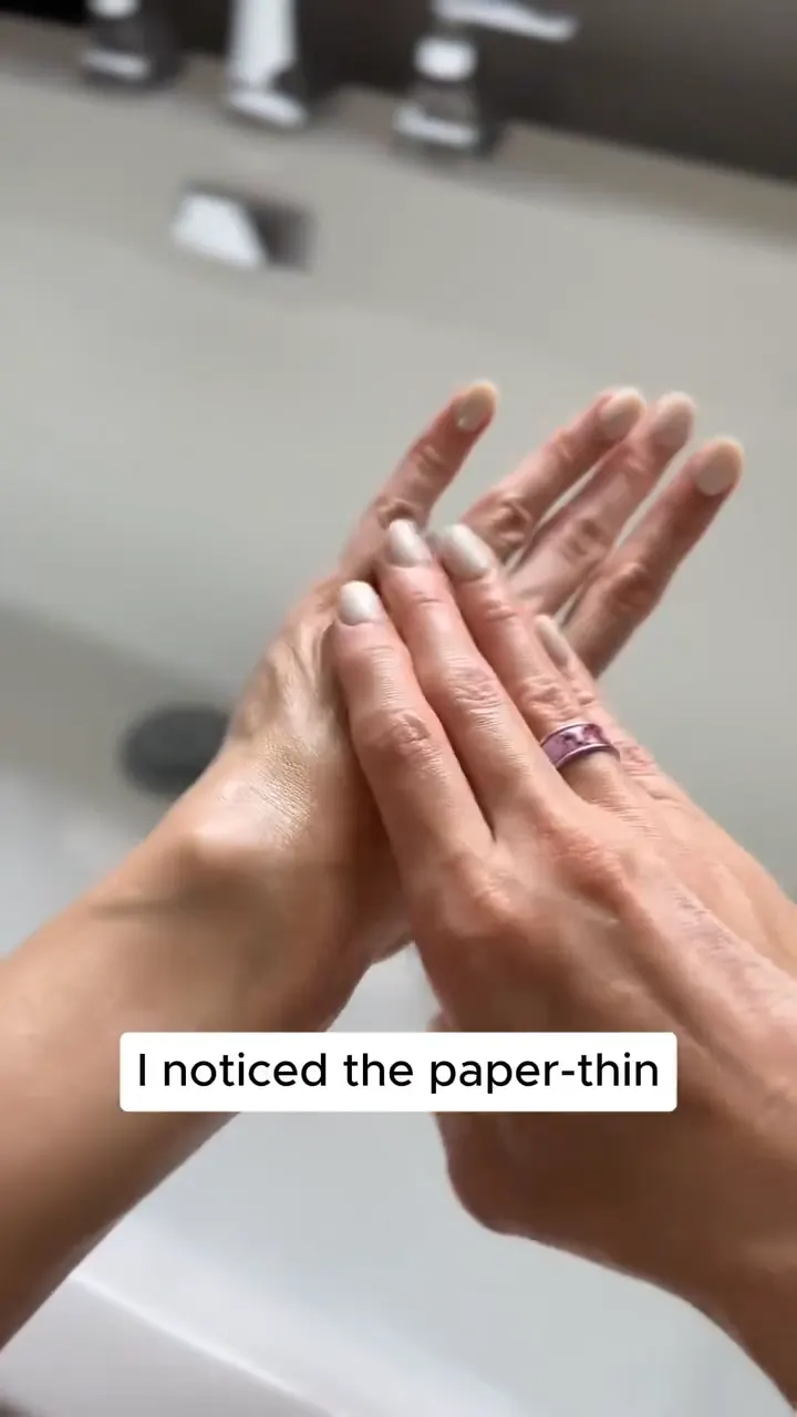 Hands applying body serum in a bathroom demonstration scene.